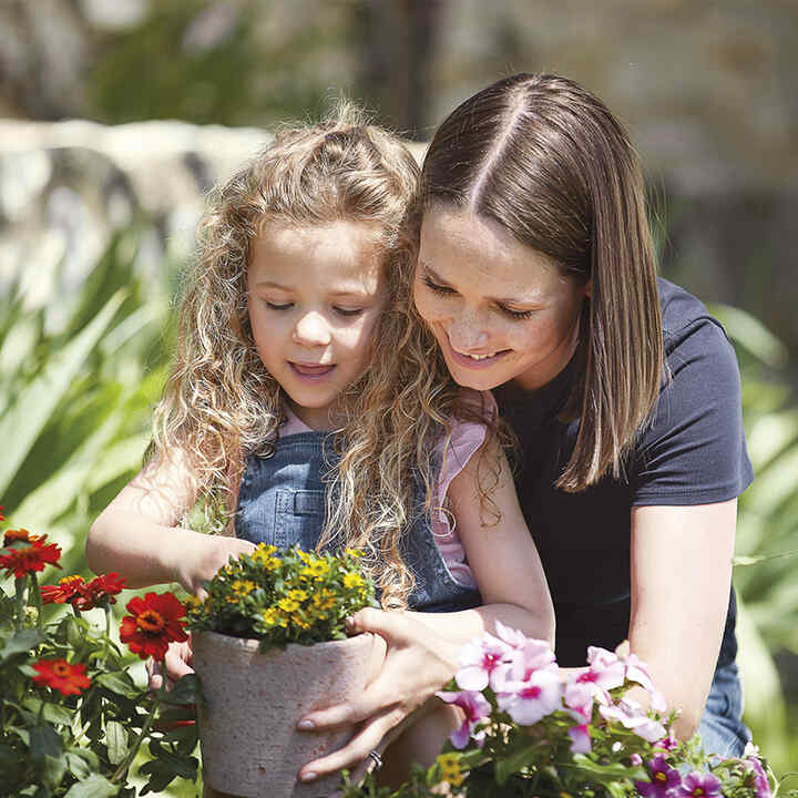 Matka s dcérkou pestujú kvety.